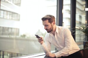 férfi a telefonját nézi
